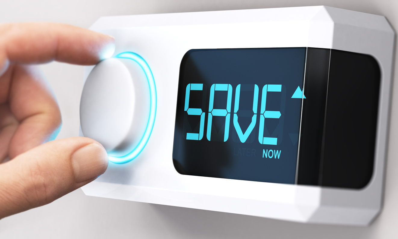 Hand turning thermostat to save money with energy management